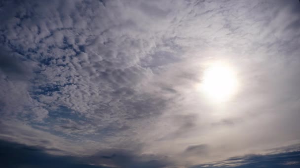 Gelaagde wolken bewegen in de blauwe lucht onder heldere zon, pluizig wolkendek Timelapse — Stockvideo