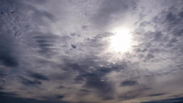 Gelaagde wolken bewegen in de blauwe lucht onder heldere zon, pluizig wolkendek Timelapse — Stockvideo