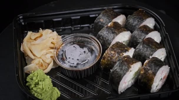 Rollos de sushi japoneses en caja de plástico está girando — Vídeos de Stock