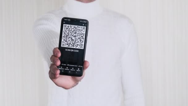 Mano masculina muestra el código QR en el teléfono inteligente sobre fondo blanco. — Vídeo de stock