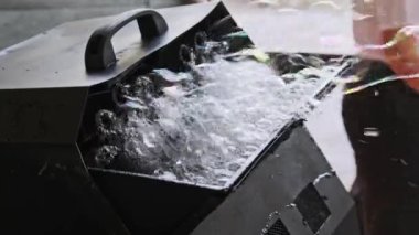 Çocukların tatilinde kullanılan otomatik sabun köpüğü üfleme makinesi. Sabun köpüğü jeneratörü açık hava festivalinde sabun köpüğü üretiyor. Yavaş çekim.