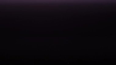 Gece gökyüzünde fırtınalı bulutlarda şimşekler çakıyor. Gece büyük bir şimşek çaktı. Şehir ufkunun üzerinde karanlık gökyüzü. Şiddetli bulutlar birden fazla şimşek ve fırtına patlaması getirir. Yavaş Hareket 4K