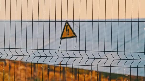 Знак Высокого Напряжения Проволочном Заборе Солнечной Электростанции Желтый Треугольный Знак — стоковое видео