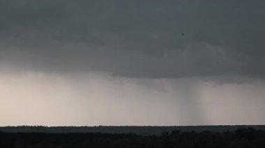 Fırtına bulutlarında şimşek çakıyor. Şiddetli bulutlar birden fazla şimşek ve fırtına patlaması getirir. Orman ufkunun üzerinde gece vakti büyük şimşekler çakar. Ağır çekim. 4K