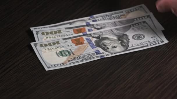 黒の木製のテーブルの上に新しい100ドル紙幣を数える 男性の手は紙幣 現金を数える 100ドル札を数える手のクローズアップ ビジネス 経済の概念 — ストック動画