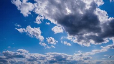 Katmanlı bulutların zaman akışı parlak güneşin altında mavi gökyüzünde ilerler. Cirrus bulutları şekil değiştirir ve bulut uzayında çözünür. Görkemli pofuduk gökyüzü. Bulutlu zaman çizelgesi. Hava değişimi. İnanılmaz doğa 4K