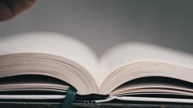 Kitap çevirme sayfaları, yakın çekim, yavaş çekim. Erkek eli bir kitabın sayfalarını karıştırır, seçici odaklanma. Kalın bir kitabın sayfalarını hızlıca çeviriyorum. Ayrıntılı görüş. Okuma, öğrenme, kendini eğitme.