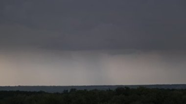 Fırtına bulutlarında şimşek çakıyor. Şiddetli bulutlar birden fazla şimşek ve fırtına patlaması getirir. Orman ufkunun üzerinde gece vakti büyük şimşekler çakar. Ağır çekim. 4K