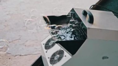 Sabun köpüğü jeneratörü açık hava festivalinde sabun köpüğü üretiyor. Çocukların tatilinde kullanılan otomatik sabun köpüğü üfleme makinesi. Yavaş çekim.