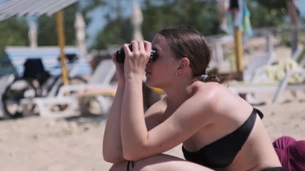 Menina Bonita Olha Através Binóculos Praia Uma Jovem Morena Sentada — Vídeo de Stock