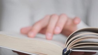Kitap okumak ve sayfaları çevirmek, kapat. Genç adam bir kitap tutuyor ve sayfaları çeviriyor, ağır çekimde. Tanımlanamayan bir adam kitap okuyor ve sayfaları karıştırıyor. Kendi kendini eğitme