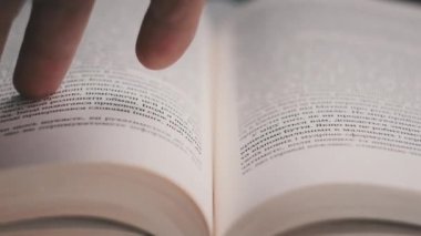 Kitap çevirme sayfaları, yakın çekim, yavaş çekim. Erkek eli bir kitabın sayfalarını karıştırır, seçici odaklanma. Kalın bir kitabın sayfalarını hızlıca çeviriyorum. Ayrıntılı görüş. Okuma, öğrenme, kendini eğitme.