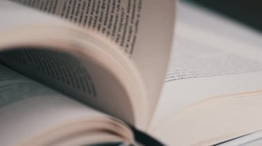 Kitap çevirme sayfaları, yakın çekim, yavaş çekim. Erkek eli bir kitabın sayfalarını karıştırır, seçici odaklanma. Kalın bir kitabın sayfalarını hızlıca çeviriyorum. Ayrıntılı görüş. Okuma, öğrenme, kendini eğitme.
