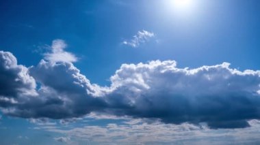 Kümülüs bulutlarının mavi gökyüzünde güneşin altında hareket etme zamanı. Bulutlar bulut uzayında şekillerini değiştirirler. Harika bir gökyüzü. Dramatik atmosfer geçmişi, zaman atlaması. Hava değişikliği. Doğa. 4K