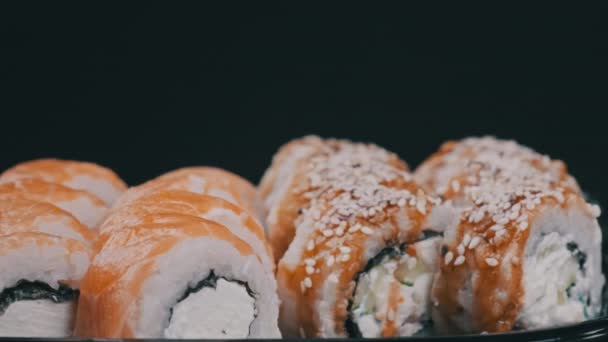 Rolos Sushi Caixa Plástico Girar Sobre Fundo Preto Close Sushi — Vídeo de Stock