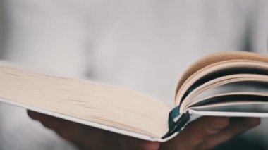 Genç adam kitap okuyor ve sayfaları çeviriyor, kapat, yavaş çekim. Erkek eller bir kitap tutuyor ve sayfaları çeviriyor. Tanımlanamayan bulanık bir adam metni inceliyor. Öğrenme, kendini eğitme. 4K