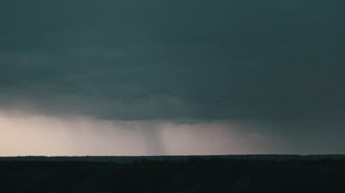 Fırtına bulutlarında şimşek çakıyor. Şiddetli bulutlar birden fazla şimşek ve fırtına patlaması getirir. Orman ufkunun üzerinde gece vakti büyük şimşekler çakar. Ağır çekim. 4K