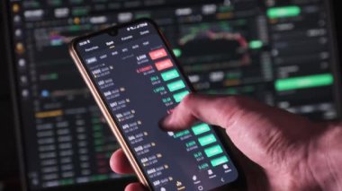 Yatırımcı akıllı telefon ekranındaki kripto para birimini kontrol ediyor. Birçok kripto varlığı büyüme gösteriyor. Yeşil portföy. Döviz kurunun borsa çizelgeleri. İşadamı dijital borsa yatırımlarını analiz ediyor