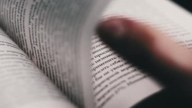 Kitap çevirme sayfaları, yakın çekim, yavaş çekim. Erkek eli bir kitabın sayfalarını karıştırır, seçici odaklanma. Kalın bir kitabın sayfalarını hızlıca çeviriyorum. Ayrıntılı görüş. Okuma, öğrenme, kendini eğitme.