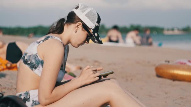 Giovane Donna Utilizza Uno Smartphone Sulla Spiaggia Bella Ragazza Costume — Video Stock