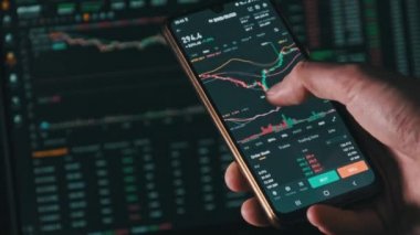 Akıllı telefondaki dijital pazarda kripto fiyat grafiği analizi yapan bir yatırımcı. Kripto para birimi gelecek fiyat öngörüsü konsepti. Ekrana dokunan adam, döviz piyasası verilerine göz atın, yakın plan.