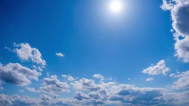 Katmanlı bulutların zaman akışı parlak güneşin altında mavi gökyüzünde ilerler. Cirrus bulutları şekil değiştirir ve bulut uzayında çözünür. Görkemli pofuduk gökyüzü. Bulutlu zaman çizelgesi. Hava değişimi. İnanılmaz doğa 4K