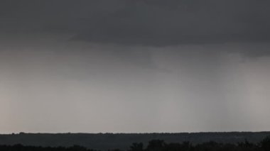 Fırtına bulutlarında şimşek çakıyor. Şiddetli bulutlar birden fazla şimşek ve fırtına patlaması getirir. Orman ufkunun üzerinde gece vakti büyük şimşekler çakar. Ağır çekim. 4K