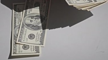 Counting old hundred dollar banknotes on a white table. Male hands counting paper money, home cash. Close-up of a hand counting 100 USD bills. Business, finance, economy concept.