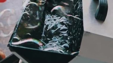 Sabun köpüğü jeneratörü açık hava festivalinde sabun köpüğü üretiyor. Çocukların tatilinde kullanılan otomatik sabun köpüğü üfleme makinesi. Yavaş çekim.