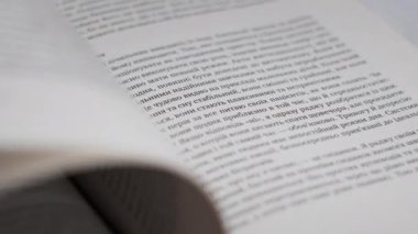 Kitap çevirme sayfaları, yakın çekim, yavaş çekim. Erkek eli bir kitabın sayfalarını karıştırır, seçici odaklanma. Kalın bir kitabın sayfalarını hızlıca çeviriyorum. Ayrıntılı görüş. Okuma, öğrenme, kendini eğitme.