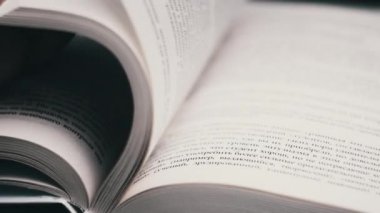 Kitap çevirme sayfaları, yakın çekim, yavaş çekim. Erkek eli bir kitabın sayfalarını karıştırır, seçici odaklanma. Kalın bir kitabın sayfalarını hızlıca çeviriyorum. Ayrıntılı görüş. Okuma, öğrenme, kendini eğitme.