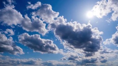 Katmanlı bulutların zaman akışı parlak güneşin altında mavi gökyüzünde ilerler. Cirrus bulutları şekil değiştirir ve bulut uzayında çözünür. Görkemli pofuduk gökyüzü. Bulutlu zaman çizelgesi. Hava değişimi. İnanılmaz doğa 4K