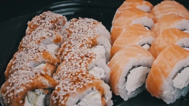 Sushi Tekercsek Műanyag Dobozban Forognak Közelről Elvitt Friss Japán Sushi — Stock videók