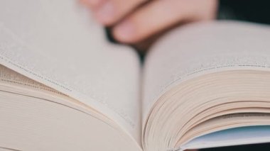 Kitap okumak ve sayfaları çevirmek, kapat. Genç adam bir kitap tutuyor ve sayfaları çeviriyor, ağır çekimde. Tanımlanamayan bir adam kitap okuyor ve sayfaları karıştırıyor. Kendi kendini eğitme