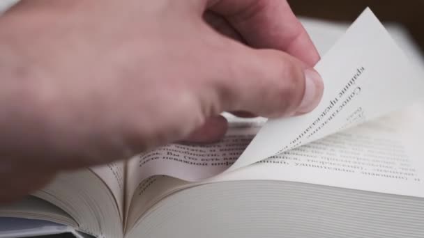 翻开一本书的几页特写 动作缓慢 男性的手翻阅着一本书的书页 有选择性地集中注意力 快速翻阅一本厚厚的书 详细视图 — 图库视频影像