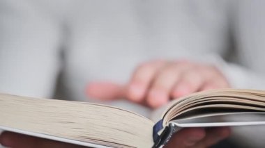 Kitap okumak ve sayfaları çevirmek, kapat. Genç adam bir kitap tutuyor ve sayfaları çeviriyor, ağır çekimde. Tanımlanamayan bir adam kitap okuyor ve sayfaları karıştırıyor. Kendi kendini eğitme