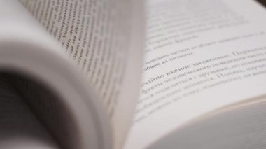 Kitap çevirme sayfaları, yakın çekim, yavaş çekim. Erkek eli bir kitabın sayfalarını karıştırır, seçici odaklanma. Kalın bir kitabın sayfalarını hızlıca çeviriyorum. Ayrıntılı görüş. Okuma, öğrenme, kendini eğitme.