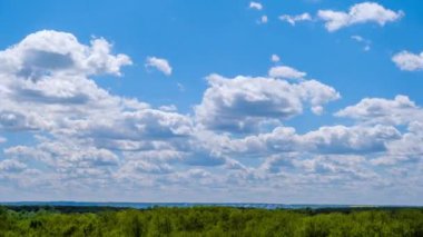 Kümülüs bulutlarının zaman çizelgesi yeşil ufukta mavi gökyüzünde hareket ediyor. Işık bulutları bulut uzayında şekillerini değiştirirler. Bulutların arka planı, zaman atlaması. Anlaşıldı uzay, hava, doğa. 4K