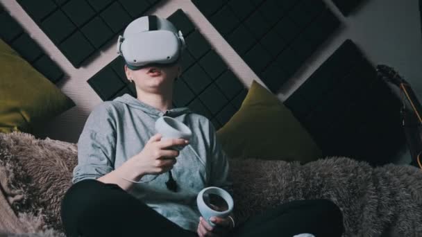 Young Woman Virtual Reality Helmet Sitting Sofa Moving Joysticks Her — Stock Video