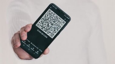 Erkek el, beyaz arka planda akıllı telefondaki QR kodunu gösteriyor. Cep telefonu ekranındaki yazı - QR kodunu tara. İzole edilmiş. Dijital para kavramı, güvenli, ilaç, covid, ödeme, dijitalleştirme
