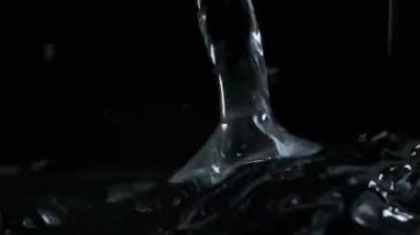 Yavaş çekimde suyun yüzeyine çok su damlası düşer, makro çekim. Damlalar sıvı yüzeyi vurarak dalgalar, daireler ve sıvı türbülans oluşturur. Yüzey gerilimi. 240 fps.