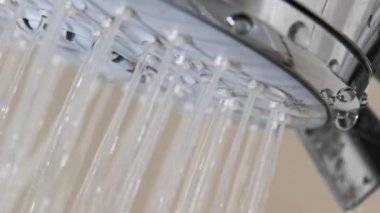 Banyodaki duş başlığından akan su damlalarını yavaş çekimde kapatın. Duş başlığının makro görüntüsü, suyun açılıp kapanması. Yüksek hızlı kamerada musluktan su akıyor. 240fps.