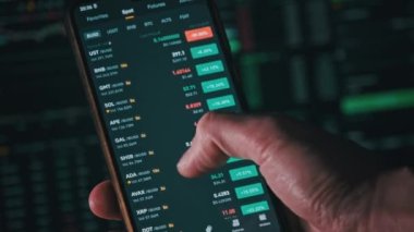 Yatırımcı akıllı telefon ekranındaki kripto para birimini kontrol ediyor. Birçok kripto varlığı büyüme gösteriyor. Yeşil portföy. Döviz kurunun borsa çizelgeleri. İşadamı dijital borsa yatırımlarını analiz ediyor