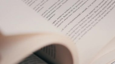 Kitap çevirme sayfaları, yakın çekim, yavaş çekim. Erkek eli bir kitabın sayfalarını karıştırır, seçici odaklanma. Kalın bir kitabın sayfalarını hızlıca çeviriyorum. Ayrıntılı görüş. Okuma, öğrenme, kendini eğitme.