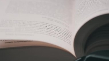 Kitap çevirme sayfaları, yakın çekim, yavaş çekim. Erkek eli bir kitabın sayfalarını karıştırır, seçici odaklanma. Kalın bir kitabın sayfalarını hızlıca çeviriyorum. Ayrıntılı görüş. Okuma, öğrenme, kendini eğitme.