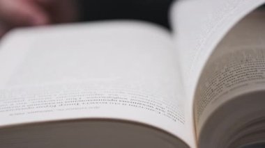 Kitap çevirme sayfaları, yakın çekim, yavaş çekim. Erkek eli bir kitabın sayfalarını karıştırır, seçici odaklanma. Kalın bir kitabın sayfalarını hızlıca çeviriyorum. Ayrıntılı görüş. Okuma, öğrenme, kendini eğitme.