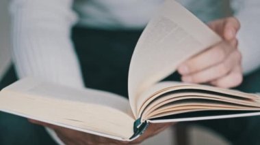 Genç adam kitap okuyor ve sayfaları çeviriyor, kapat, yavaş çekim. Erkek eller bir kitap tutuyor ve sayfaları çeviriyor. Tanımlanamayan bulanık bir adam metni inceliyor. Öğrenme, kendini eğitme. 4K