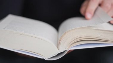 Kitap okumak ve sayfaları çevirmek, kapat. Genç adam bir kitap tutuyor ve sayfaları çeviriyor, ağır çekimde. Tanımlanamayan bir adam kitap okuyor ve sayfaları karıştırıyor. Kendi kendini eğitme