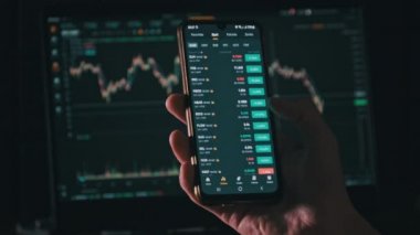 Yatırımcı akıllı telefon ekranındaki kripto para birimini kontrol ediyor. Birçok kripto varlığı büyüme gösteriyor. Yeşil portföy. Döviz kurunun borsa çizelgeleri. İşadamı dijital borsa yatırımlarını analiz ediyor