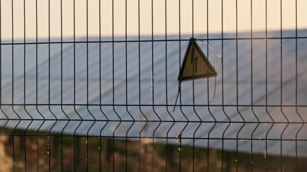 Hoogspanningsbord Een Draadhek Van Zonnecentrale Gele Driehoekige Teken Bliksem Gevaar — Stockvideo